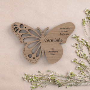 uma lembrança borboleta em carvalho com ramos de flores ao lado uma lembrança borboleta em carvalho com ramos de flores ao lado