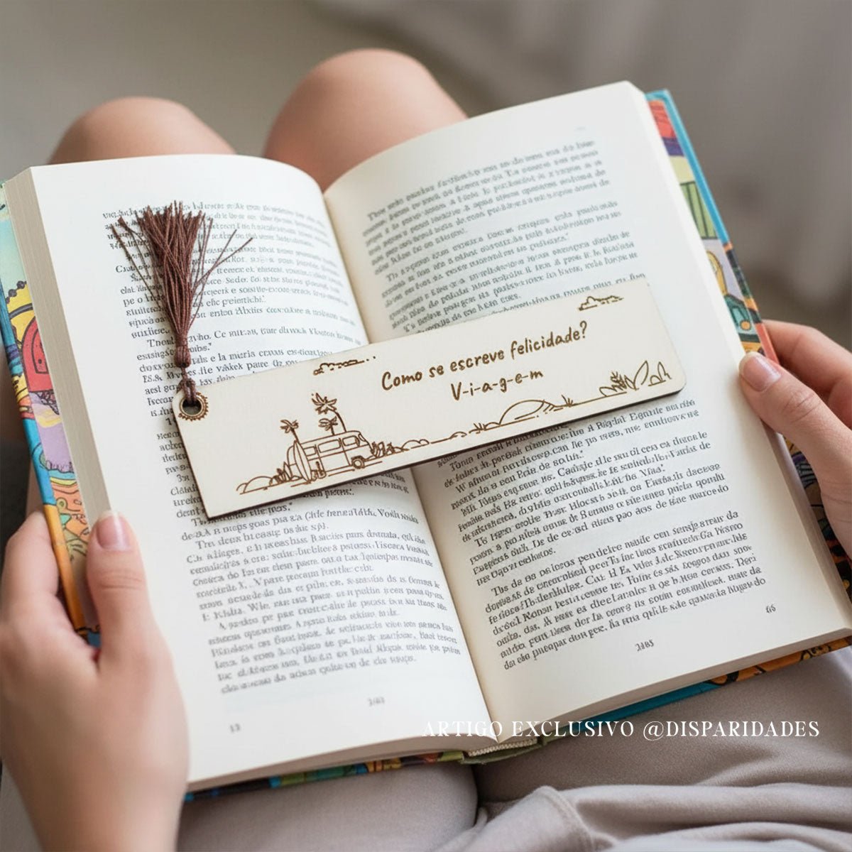 um marcador rústico sobre um livro aberto sobre o colo de uma mulher