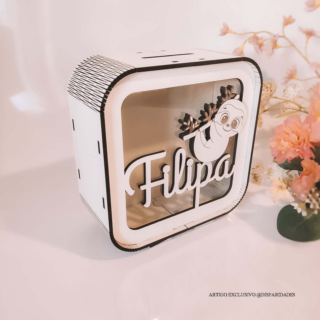 um mealheiro branco com o nome filipa e acima do nome uma imagem de uma preguiça