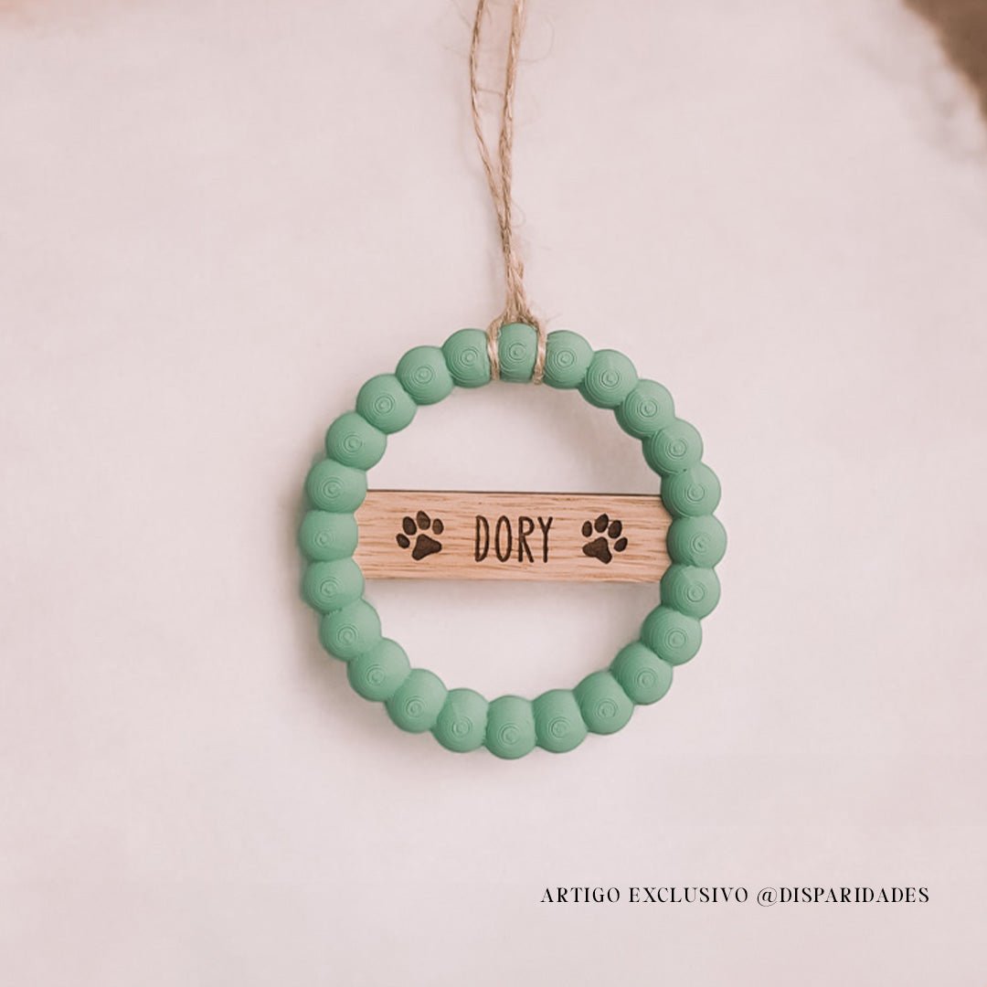 Pendente de Natal de contas verdes com uma placa de madeira personalizada com o nome "Dory" e pegadas gravadas. Pendurada por corda rústica, estilo simples e artesanal.