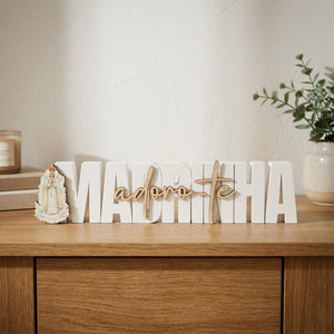 Vista frontal da placa decorativa branca Madrinha Adoro-te com Nossa Senhora de Fátima e lettering em madeira natural. Vista frontal da placa decorativa branca Madrinha Adoro-te com Nossa Senhora de Fátima e lettering em madeira natural.