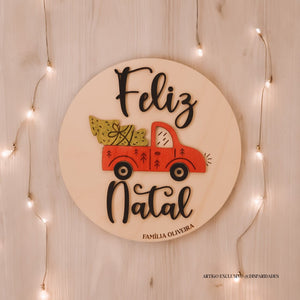 Placa de madeira com o texto "Feliz Natal" em preto, ilustrada com uma carrinha vermelha que transporta uma árvore e presentes. Fundo rústico com luzes decorativas suaves. Placa de madeira com o texto "Feliz Natal" em preto, ilustrada com uma carrinha vermelha que transporta uma árvore e presentes. Fundo rústico com luzes decorativas suaves.