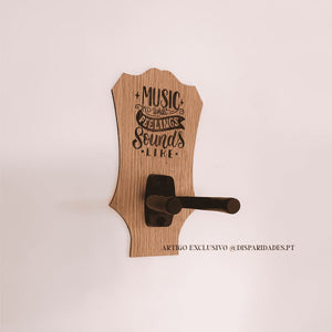 Suporte para guitarra rústico em madeira, com citação "Music is what feelings sound like" gravada. O gancho é preto, simples e moderno. Fundo branco minimalista. Suporte para guitarra rústico em madeira, com citação "Music is what feelings sound like" gravada. O gancho é preto, simples e moderno. Fundo branco minimalista.