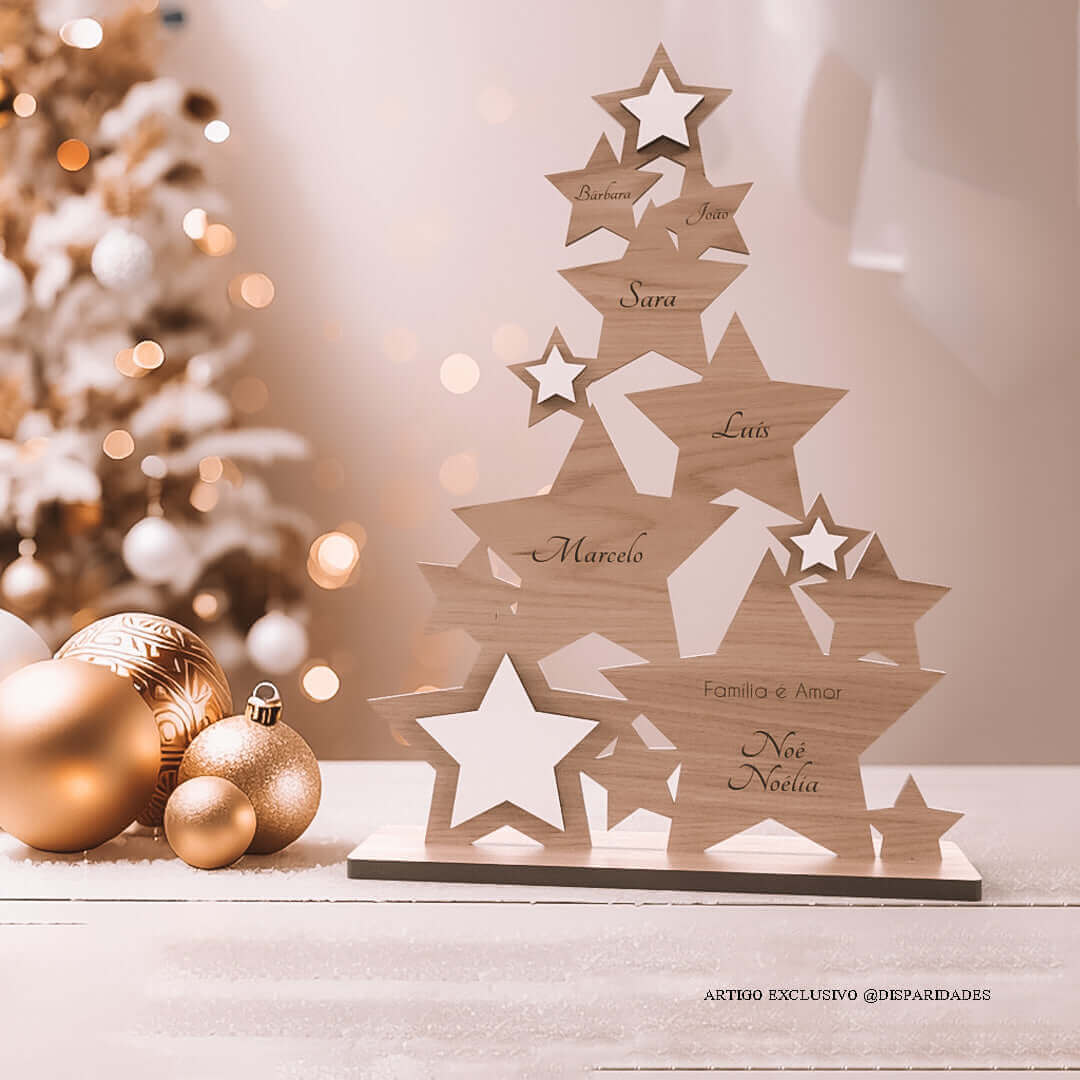 Árvore de Natal carvalho feita com formas de estrelas personalizado com os nomes da família e uma pequena frase "Família é Amor", está em cima de uma mesa ao lado de bolas de Natal douradas
