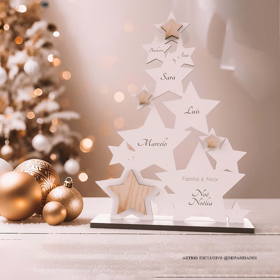 Árvore de Natal branca feita com formas de estrelas personalizado com os nomes da família e uma pequena frase "Família é Amor", está em cima de uma mesa ao lado de b