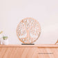 Decoração de interiores com uma peça de madeira clara em forma de árvore da vida sobre uma prateleira de madeira, personalizada com 'Amo-te Mãe - Tomás e Melanie' em um ambiente doméstico