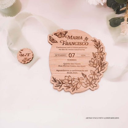 Convite de casamento rústico em madeira com forma oval, nomes "Maria & Francisco" e decoração floral gravada, acompanhado por pequeno botão com iniciais.