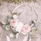 Enfeite de casamento 'you & me' em madeira com rosas e folhas de eucalipto, em fundo texturizado.