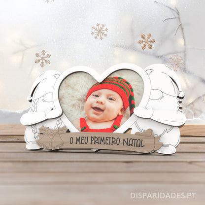 moldura em branco com dois duendes menino e menina a segurar um coração com uma foto dentro, abaixo uma frase personalizada a dizer o meu primeiro natal