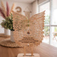uma base com asas de anjo em um ambiente bem iluminado ao estilo boho