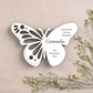 uma lembrança borboleta branca com ramos de flores ao lado