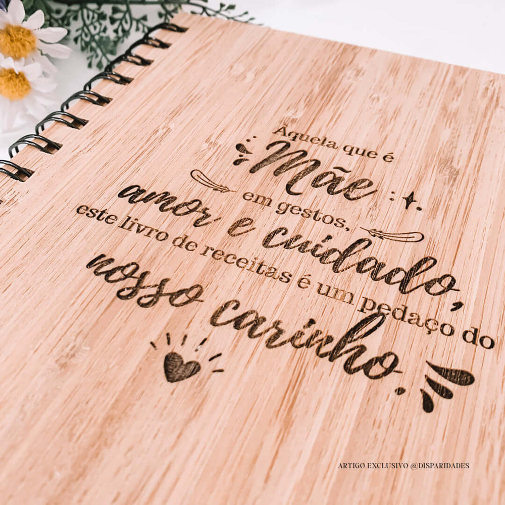 Capa de livro de receitas em madeira rústica com texto gravado: "Aquela que é Mãe em gestos, amor e cuidado, este livro de receitas é um pedaço do nosso carinho".