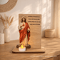 Placa de madeira com imagem do Sagrado Coração de Jesus e vela acesa, com oração religiosa gravada em português.
