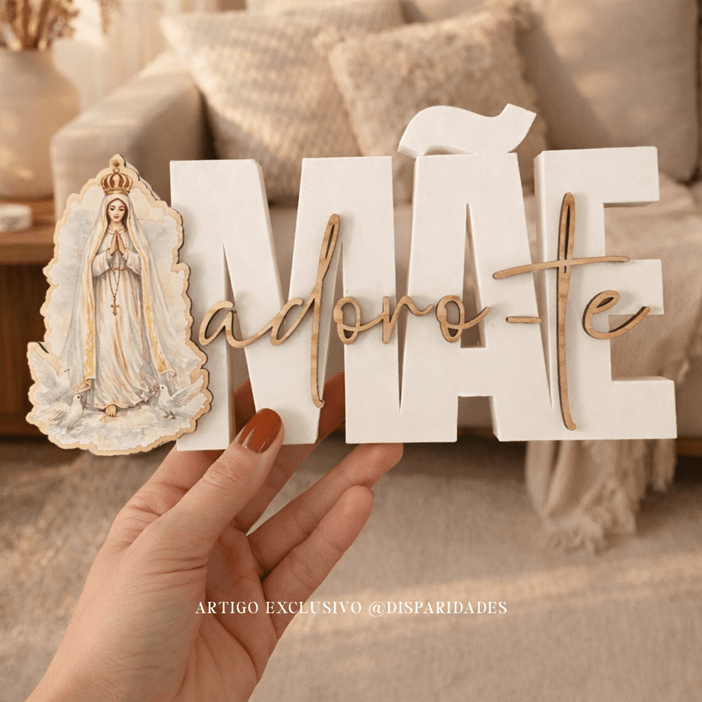 Placa decorativa “Mãe adoro-te” com imagem de Nossa Senhora, segurada na mão, em ambiente de sala com tons neutros.
