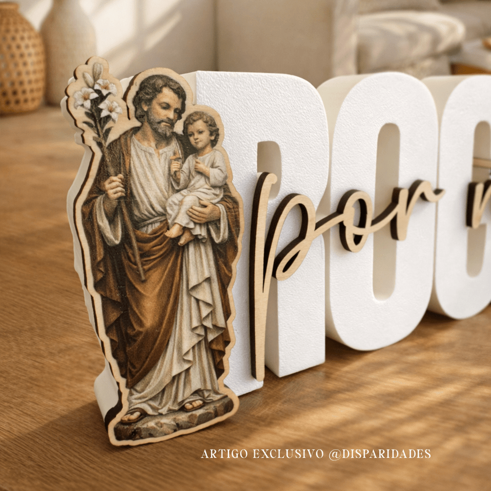 Placa decorativa rústica com “Rogai por nós” em letras brancas, detalhe em madeira e imagem de São José com o Menino Jesus, sobre mesa de madeira com luz suave.