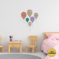 Balões personalizados para parede com diversas cores afixado na parede de um quarto de criança